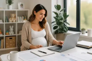 Femme enceinte travaillant sereinement sur son ordinateur à la maison, entourée de dossiers et de jouets d'enfant, dans une pièce lumineuse et bien organisée.